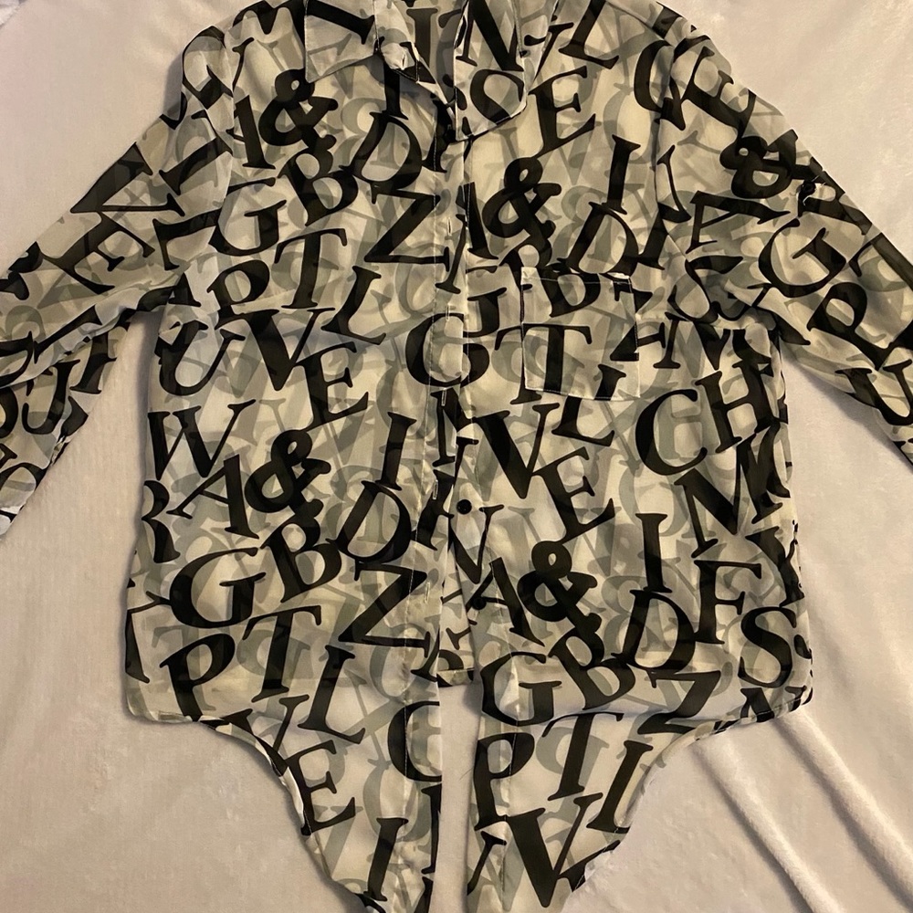 See thru lettered blouse that ties at the bottom.